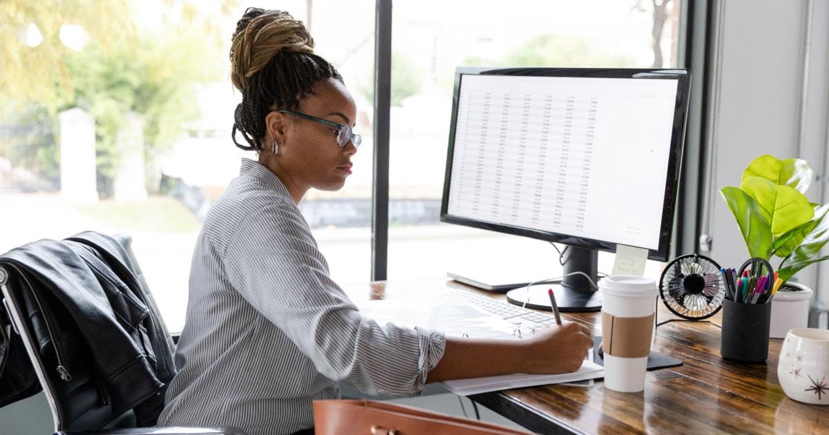 A mid adult African American businesswoman concentrates while working in her office.