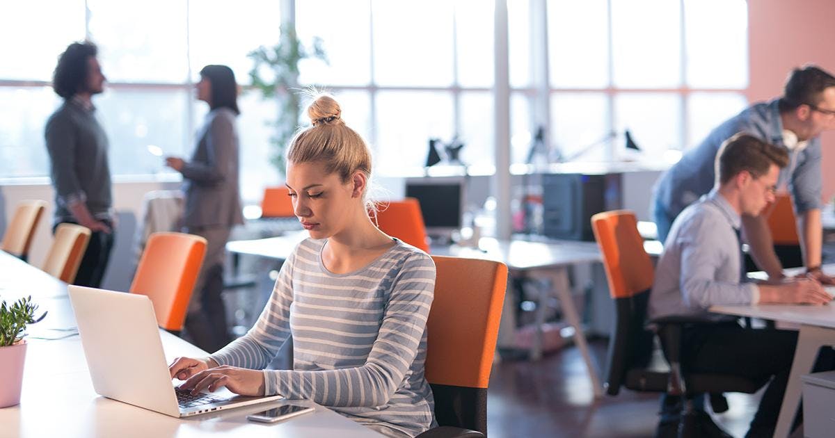 Young female Entrepreneur Freelancer Working Using A Laptop In Coworking space