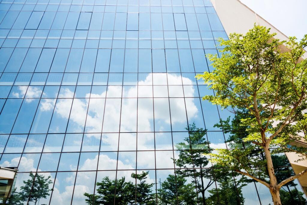 Blue sky reflected on wall of modern office building.