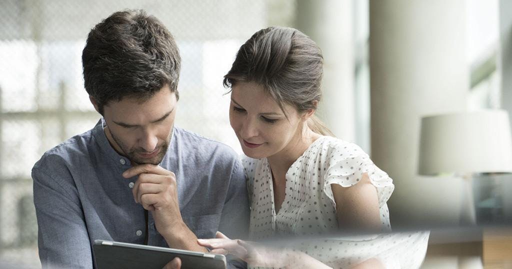 Couple using digital tablet together at home