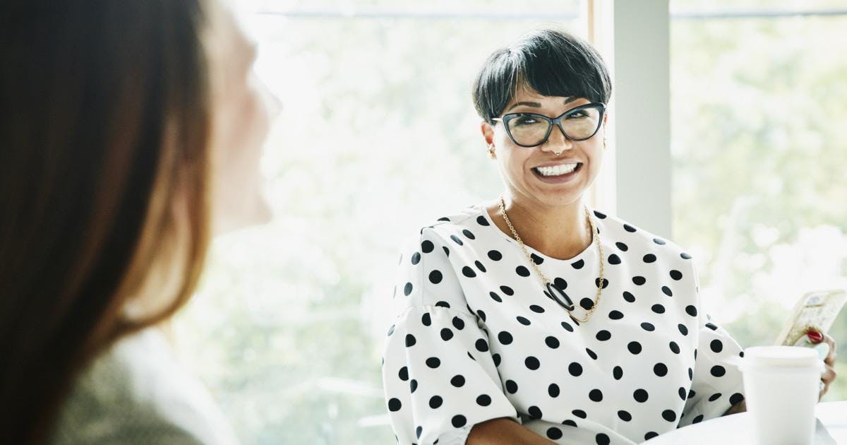 Smiling businesswoman in discussion with colleague in office conference room