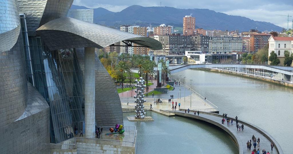 "Aerial view of tourists on walkway over urban canal, Bilbao, Biscay, Spain"